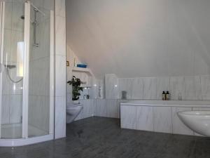 a bathroom with a tub and a sink and a toilet at Privatzimmer Ahlten in Lehrte +4 photos