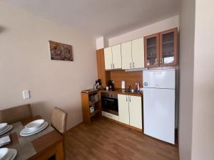 een keuken met een witte koelkast en een tafel bij Eagle Rock Apartment 222 in Beli Iskar