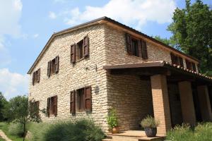 un vieux bâtiment en briques avec des fenêtres latérales dans l'établissement Agriturismo Valdifiori, à Sassoferrato