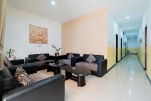 a living room with couches and tables in a building at RedDoorz near Taman Krida Budaya Malang in Malang