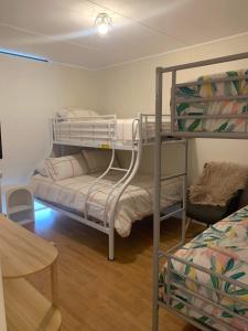 a room with two bunk beds and a table at Investigator Beach Breeze Apartments U1 in Kingscote