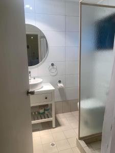 a bathroom with a shower and a sink and a mirror at Investigator Beach Breeze Apartments U1 in Kingscote