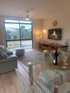 a living room with a couch and a table and chairs at Investigator Beach Breeze Apartments U1 in Kingscote
