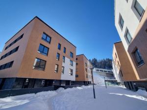 a group of buildings in the snow next to a street at Mek lux Bjelasnica in Bjelašnica