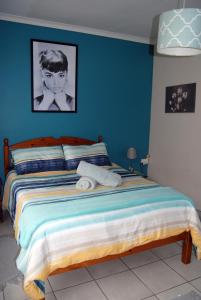 a bedroom with a bed with a blue wall at Stop-a-While in Krugersdorp