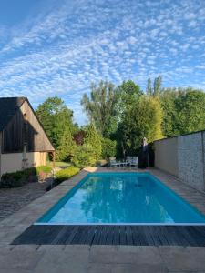 una piscina con una persona parada junto a una casa en Le Relais, en Arnage