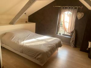 1 dormitorio con cama y ventana en Le Relais, en Arnage