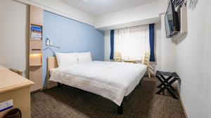 a bedroom with a white bed and a window at Toyoko Inn Gotemba Ekimae in Gotemba