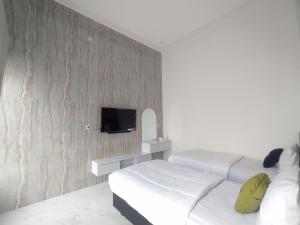 Una televisión o centro de entretenimiento en Urbanview Hotel Nimara Ngawi by RedDoorz