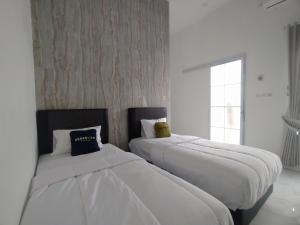 Una cama o camas en una habitación de Urbanview Hotel Nimara Ngawi by RedDoorz