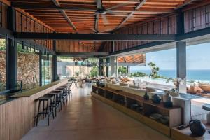 a restaurant with a bar with a view of the ocean at Tampah Hills in Selong Belanak