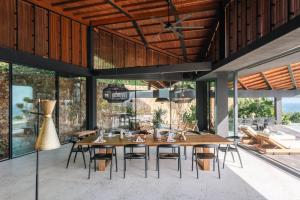 a dining room with a large wooden table and chairs at Tampah Hills in Selong Belanak