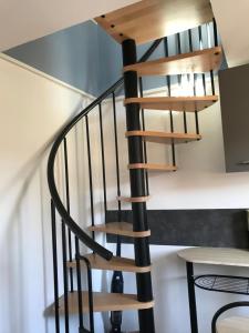 - un escalier en bois en colimaçon dans une maison dans l'établissement Jolie maisonnette, à Auxerre