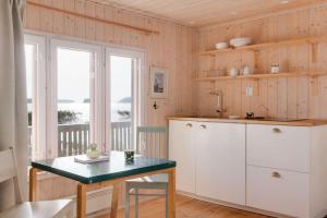 a kitchen with white cabinets and a table and a window at Villa Merituuli - Charming Seafront Cottage in Porvoo