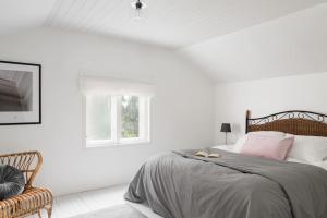 een witte slaapkamer met een bed en een raam bij Villa Merituuli - Charming Seafront Cottage in Porvoo