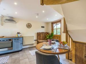 cocina con mesa de madera y electrodomésticos azules en 1 bed in Leominster 86883, 