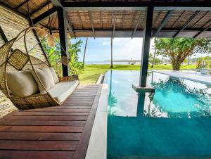 a porch with a swing next to a swimming pool at Kalinaw Resort in General Luna