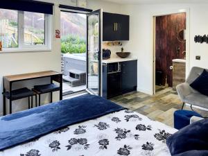 a bedroom with a bed and a desk and a kitchen at 1 Bed in Kinlochleven 87131 in Kinlochleven