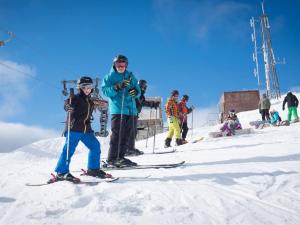 a man and a child on skis on a ski slope at 1 Bed in Kinlochleven 87131 in Kinlochleven