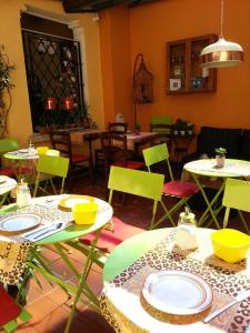 a dining room with tables and chairs with yellow and green chairs at Garni Giacometti in Locarno