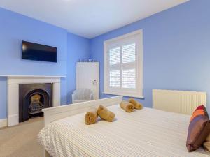 ein blaues Schlafzimmer mit 2 Betten und einem Kamin in der Unterkunft 2 Bed in Ventnor 86509 in Ventnor