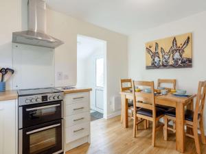 a kitchen with a table and a stove top oven at 2 Bed in Camus Croise 86437 in Isleornsay