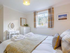 a bedroom with a white bed and a window at 2 Bed in Camus Croise 86437 in Isleornsay