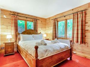sypialnia z dużym łóżkiem w pokoju z drewnianymi ścianami w obiekcie 3 Bed in Inverness 86998 w mieście Foyers