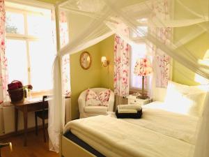 a bedroom with a canopy bed with a chair and a desk at Villa28 Self-Check- in in Aarau