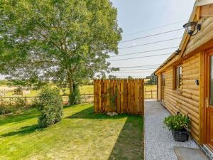 ein Holzzaun neben einem Haus mit Garten in der Unterkunft 2 bed in Stanton-by-Bridge 87408 