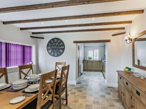 a dining room with a table and a clock on the wall at 3 Bed in Tollerton 87290 in Tollerton