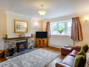 a living room with a fireplace and a television at 2 Bed in Kettlewell 87598 in Kettlewell