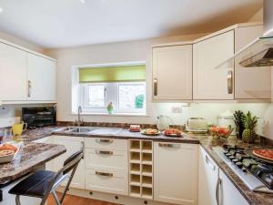 una cucina con armadi bianchi e piano di lavoro di 2 Bed in Kettlewell 87598 a Kettlewell