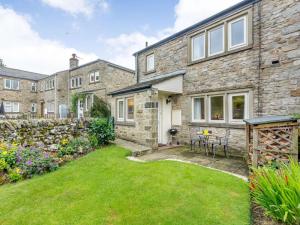 an exterior view of a stone house with a yard at 2 Bed in Kettlewell 87598 in Kettlewell