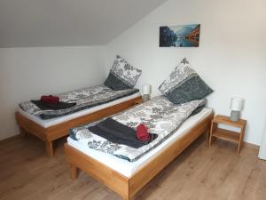 two twin beds in a room with a picture on the wall at Waldblick 
