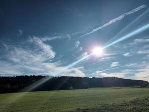 a sun shining in the sky over a field at Waldblick 