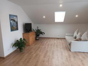 a living room with a couch and a tv at Waldblick 