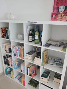 a white book shelf filled with books at Tauberperle - Exklusives Ferienapartment in Lauda-Königshofen