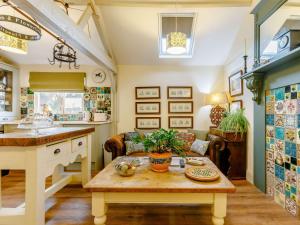 eine Küche und ein Wohnzimmer mit einem Tisch und einer Couch in der Unterkunft 1 Bed in Pershore 87365 in Birlingham + 10 Fotos