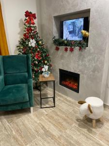 een woonkamer met een kerstboom en een open haard bij M&L Apartman Zlatibor in Zlatibor