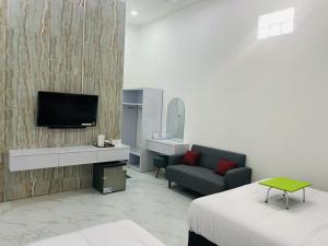 Una televisión o centro de entretenimiento en Urbanview Hotel Nimara Ngawi by RedDoorz