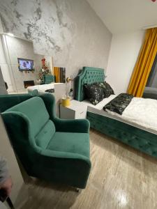 een slaapkamer met een bed, een bank en een stoel bij M&L Apartman Zlatibor in Zlatibor