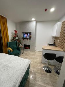 een kamer met een bed en een keuken met een kerstboom bij M&L Apartman Zlatibor in Zlatibor