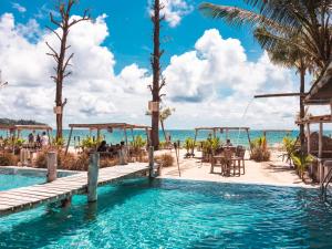 邦濤海灘的住宿－The Lazy Coconut Glamping，一座位于海滨度假胜地的游泳池