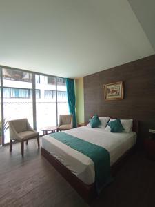 a bedroom with a large bed and a large window at The Culture Hotel And Gallery in Bogor
