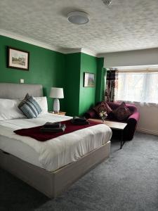 a bedroom with a bed and a green wall at Boscombe Spa Hotel in Bournemouth