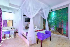 1 dormitorio con cama con dosel y silla morada en Private Pool Villas en Kuta