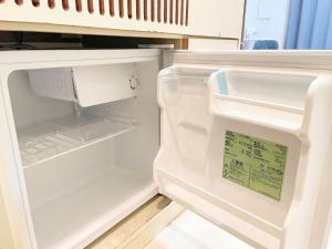 an empty refrigerator with its door open in a kitchen at 水道橋神保町 05 in Tokyo