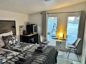 Guest house - Northern tealight في روفانييمي: غرفة نوم بسرير وطاولة وكراسي