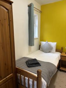 Boscombe Spa Hotel في بورنموث: غرفة نوم بسرير وستارة خضراء على الحائط